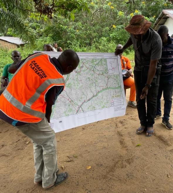 An official of the land administration shows the map of the project area to residents during a State mission