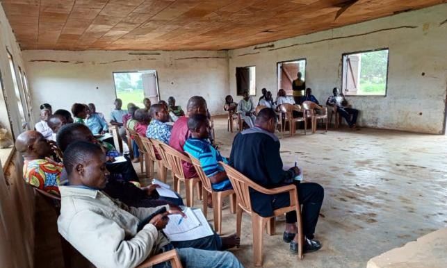Participants seated in a meeting hall at the district headquarters